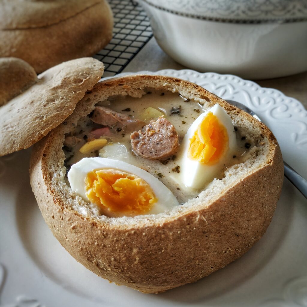 żurek podany w chlebku z jajkiem i białą kiełbasą